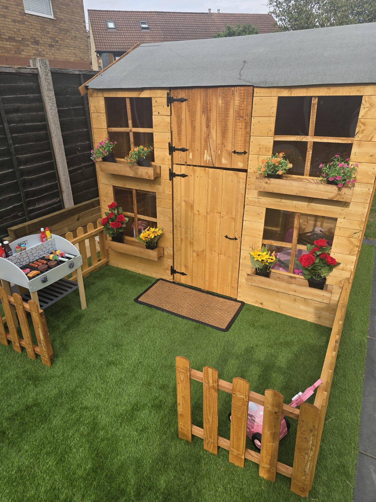 Our two-storey playhouse with flower boxes in the garden